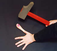 A swollen thumb being struck by a foam hammer